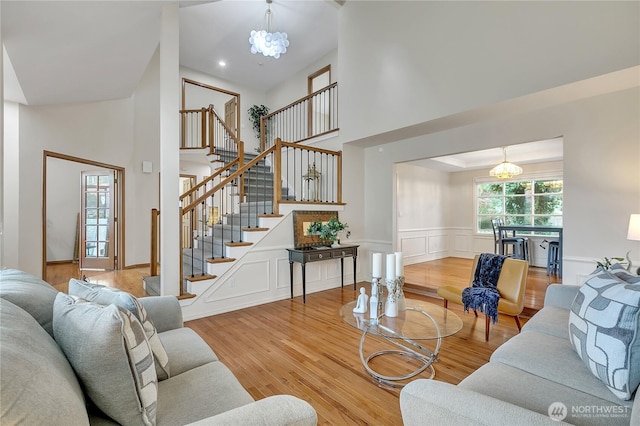 8612 165th Street Ct E, Puyallup, WA 98375 - living area with high vaulted ceiling, a chandelier, stairs, wood finished floors, and wainscoting