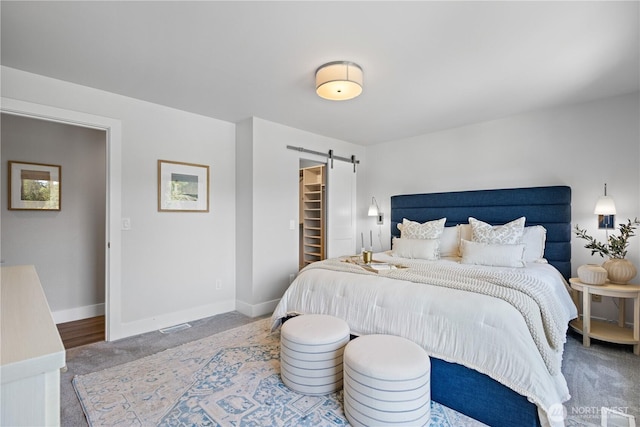 17905 NE 19th Pl, Bellevue, WA 98008 - carpeted bedroom featuring a barn door, a walk in closet, and baseboards