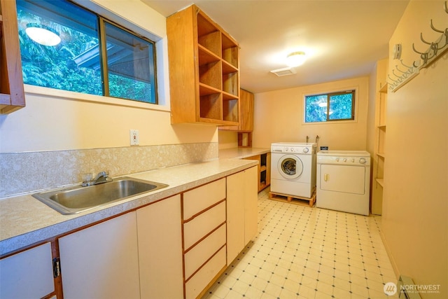 585 Raccoon Point Rd, Orcas Island, WA 98245 - laundry room featuring washing machine and clothes dryer, cabinet space, and light flooring