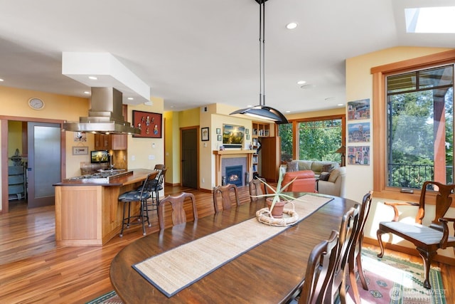 1433 Madison St, Port Townsend, WA 98368 - dining room featuring light wood finished floors, a fireplace, recessed lighting, and a skylight