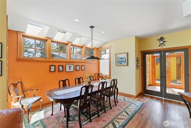 1433 Madison St, Port Townsend, WA 98368 - dining room featuring baseboards, a skylight, wood finished floors, french doors, and vaulted ceiling