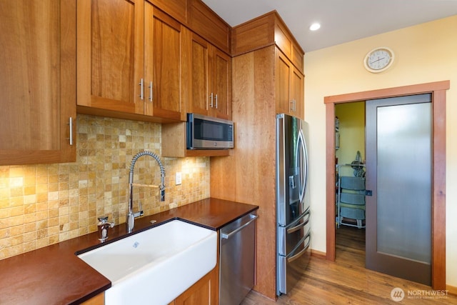 1433 Madison St, Port Townsend, WA 98368 - kitchen with stainless steel appliances, a sink, dark countertops, brown cabinets, and recessed lighting