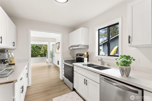 18771 Harris Ave NE, Suquamish, WA 98392 - kitchen with appliances with stainless steel finishes, under cabinet range hood, a sink, light wood-type flooring, and white cabinetry