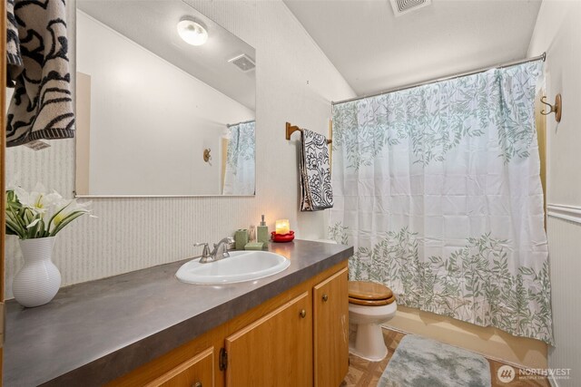 300 E Skookum Dr NE, Shelton, WA 98584 - bathroom featuring toilet, vanity, shower / bath combo with shower curtain, and vaulted ceiling