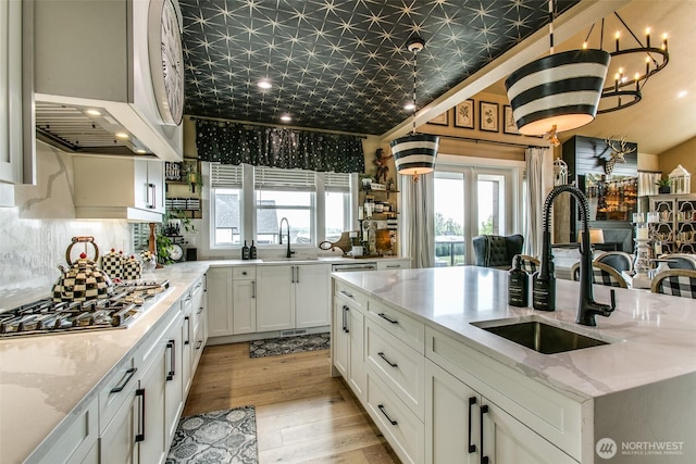1774 Farmview Ter, Lynden, WA 98264 - kitchen with stainless steel gas stovetop, a sink, white cabinets, an ornate ceiling, and light stone countertops