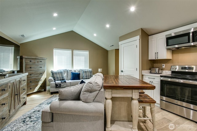 1774 Farmview Ter, Lynden, WA 98264 - kitchen featuring appliances with stainless steel finishes, white cabinetry, light wood finished floors, open floor plan, and lofted ceiling
