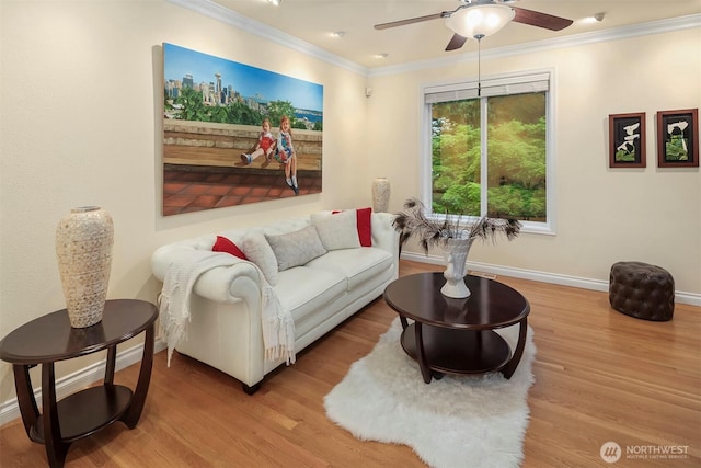 living room with ornamental molding, a ceiling fan, wood finished floors, and baseboards