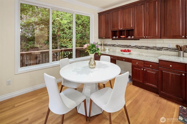 kitchen with tasteful backsplash, light wood-style floors, dark brown cabinets, and ornamental molding