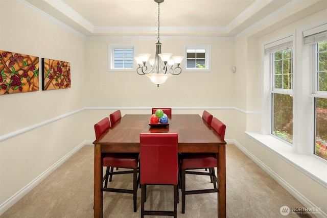 carpeted dining space with a chandelier, baseboards, and crown molding