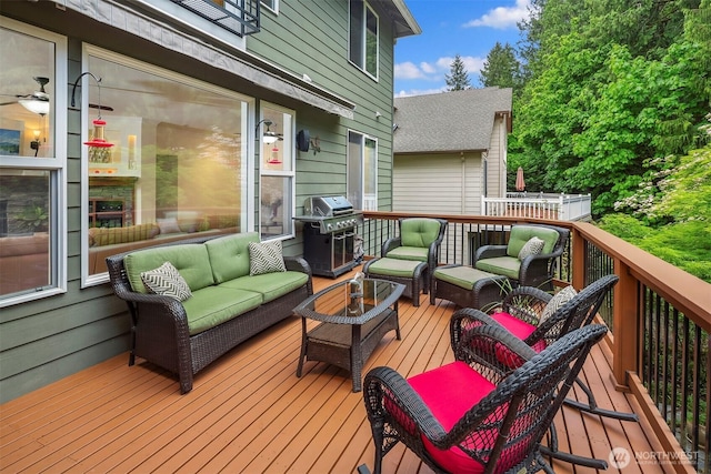 wooden terrace featuring area for grilling and an outdoor living space