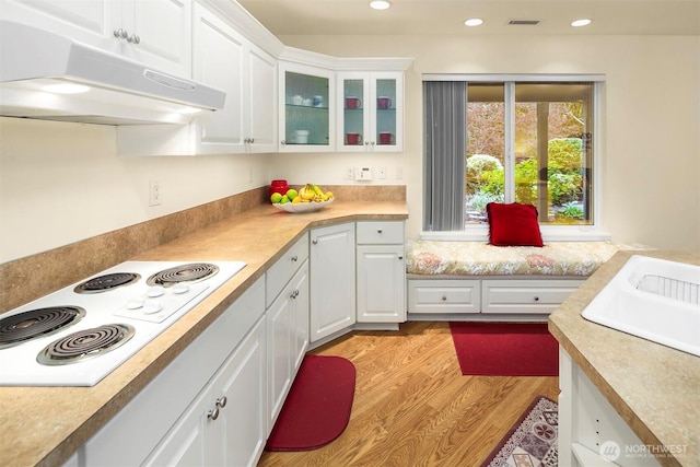 kitchen with under cabinet range hood, white electric cooktop, white cabinets, light countertops, and recessed lighting