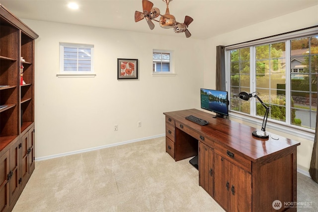 home office featuring light colored carpet, baseboards, and ceiling fan
