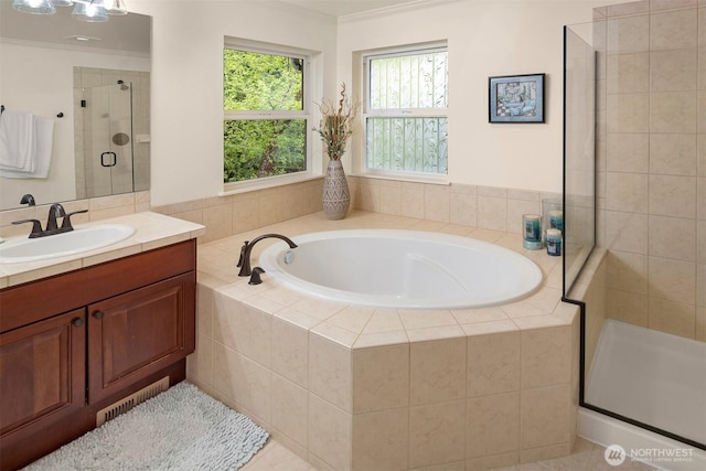 bathroom with a shower stall, ornamental molding, a garden tub, and vanity