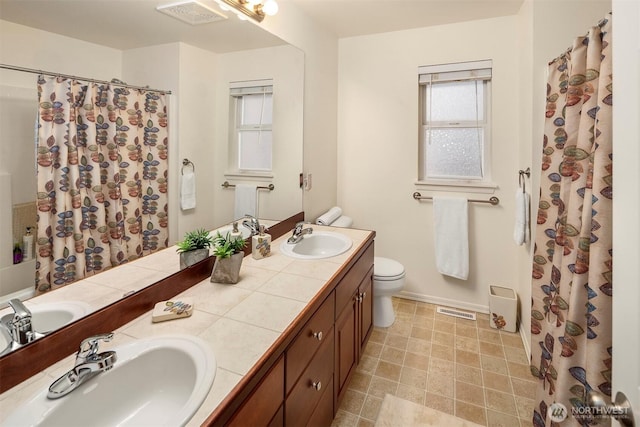 bathroom featuring toilet, baseboards, double vanity, and curtained shower