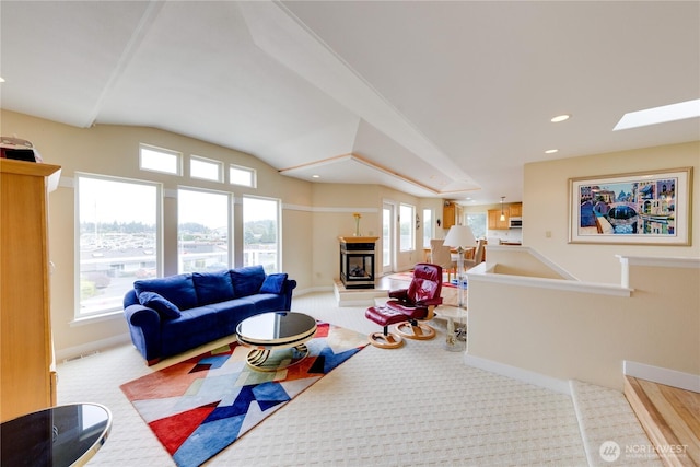 carpeted living room featuring recessed lighting, vaulted ceiling, a skylight, and baseboards