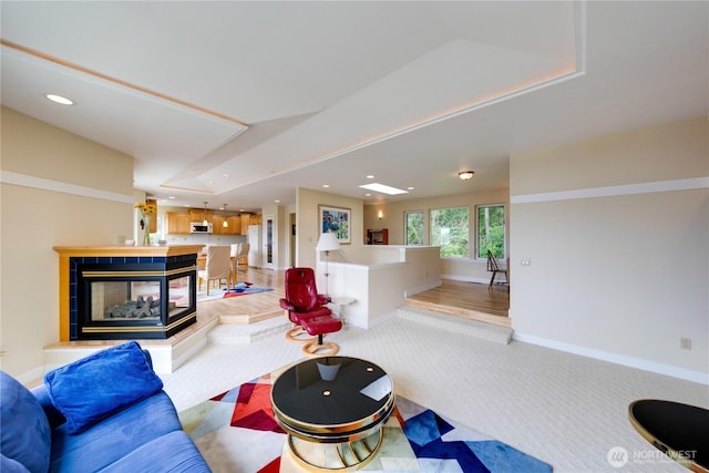 living area with light colored carpet, recessed lighting, and baseboards
