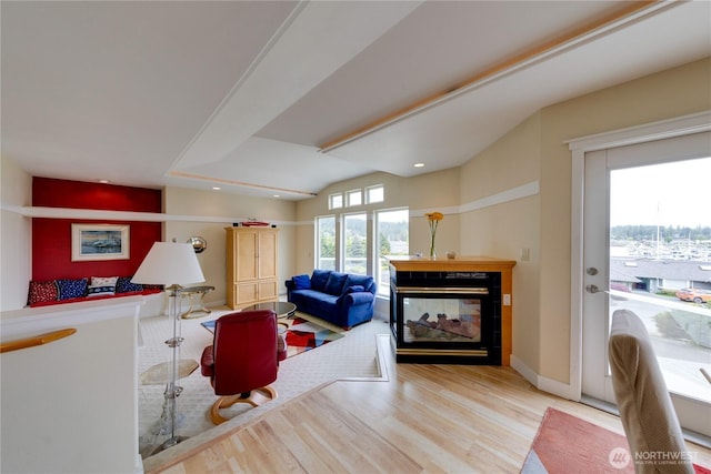 living area with wood finished floors, a fireplace, recessed lighting, and baseboards