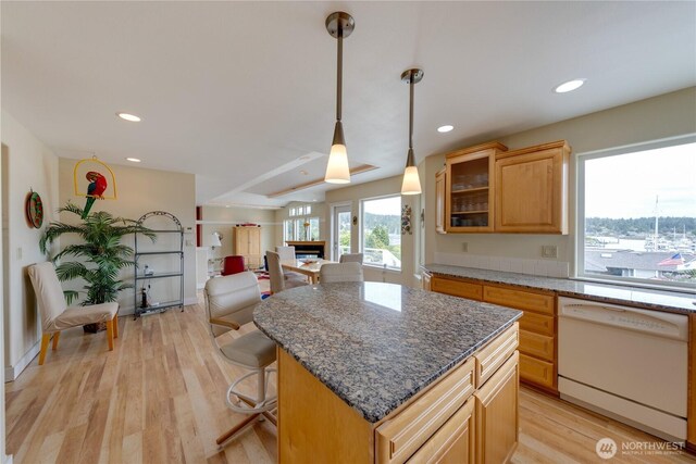 kitchen featuring dishwasher, a fireplace, a kitchen island, light wood-style flooring, and recessed lighting