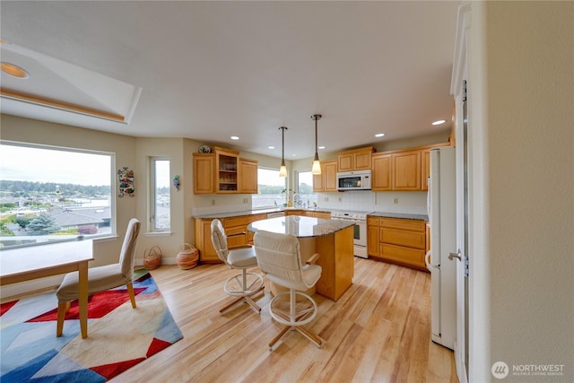 kitchen with white appliances, a kitchen island, light wood-type flooring, recessed lighting, and open shelves