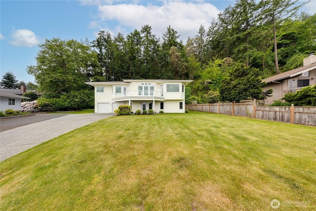 view of front of house featuring a balcony, an attached garage, and driveway