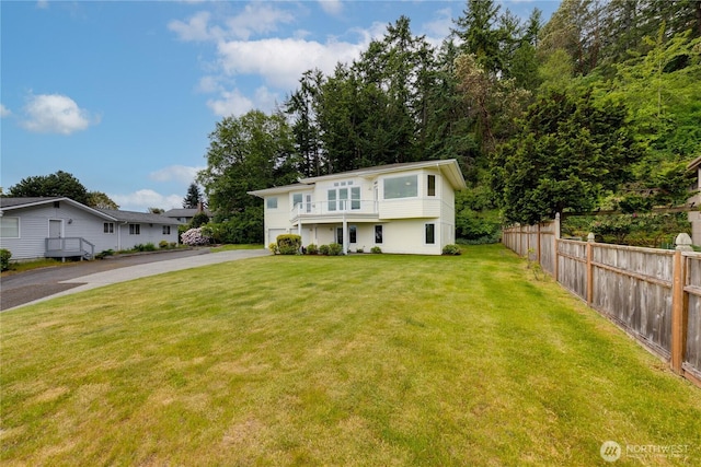 view of front facade with driveway, a balcony, and an attached garage