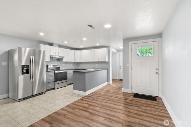 kitchen with stainless steel appliances, light wood-type flooring, white cabinetry, a sink, and recessed lighting