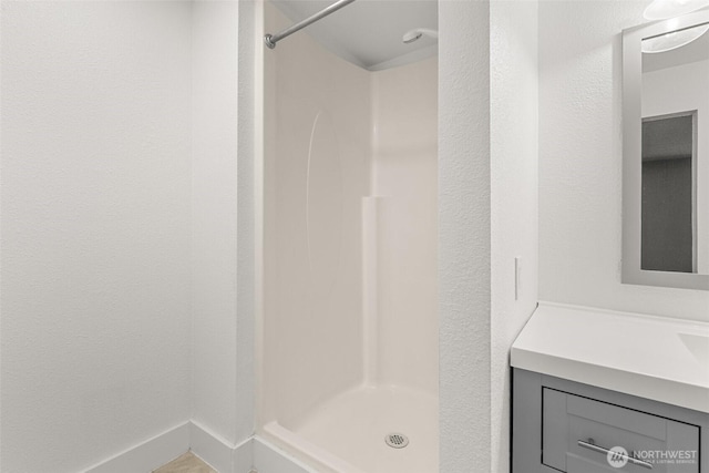 full bathroom with a shower stall and vanity