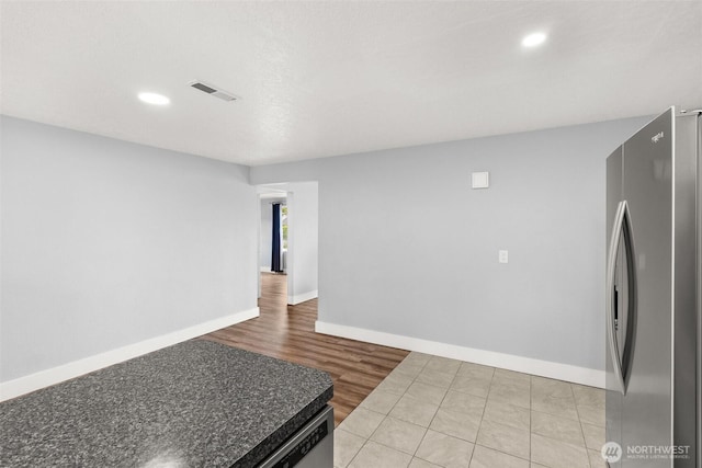 kitchen with freestanding refrigerator, baseboards, recessed lighting, light wood-type flooring, and dark countertops