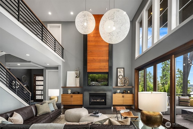 8326 84th Ave SE, Mercer Island, WA 98040 - living area with a towering ceiling, stairway, plenty of natural light, a glass covered fireplace, and recessed lighting