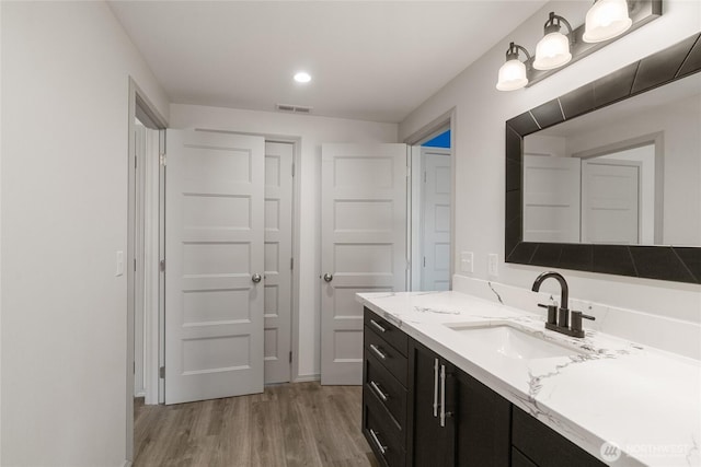 bathroom featuring wood finished floors, vanity, and recessed lighting