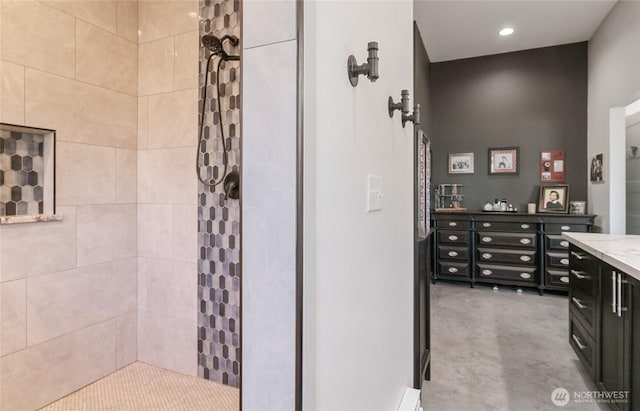 full bath with a tile shower and vanity