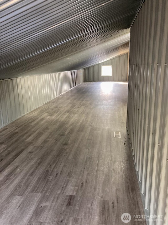 additional living space featuring lofted ceiling and wood finished floors