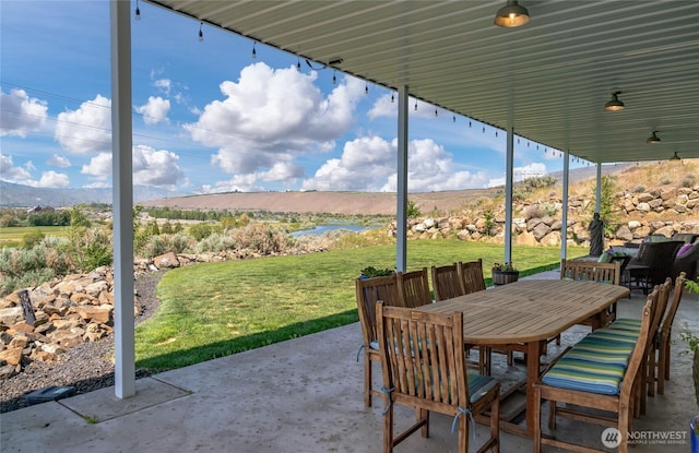 view of patio / terrace with outdoor dining area and a mountain view