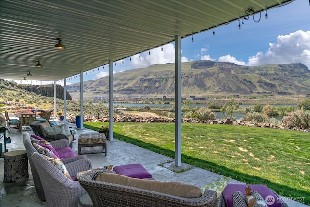 view of patio featuring a water and mountain view