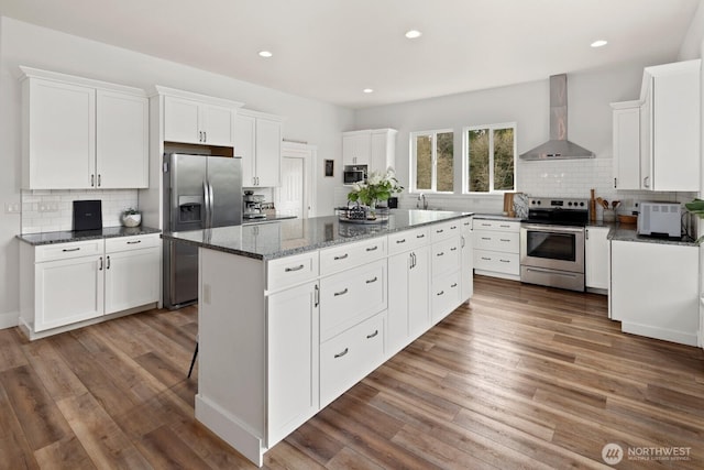 15403 127th Ave SE, Snohomish, WA 98290 - kitchen with appliances with stainless steel finishes, wall chimney exhaust hood, a kitchen island, tasteful backsplash, and recessed lighting
