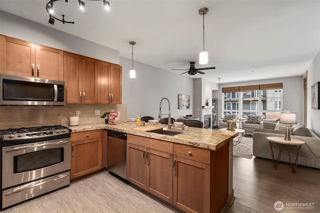 1840 25th Ave NE Unit 308, Issaquah, WA 98029 - kitchen with stainless steel appliances, a sink, a peninsula, open floor plan, and light countertops