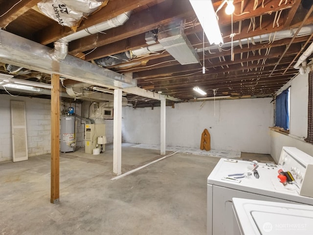 unfinished below grade area featuring water heater, washing machine and clothes dryer, and heating unit
