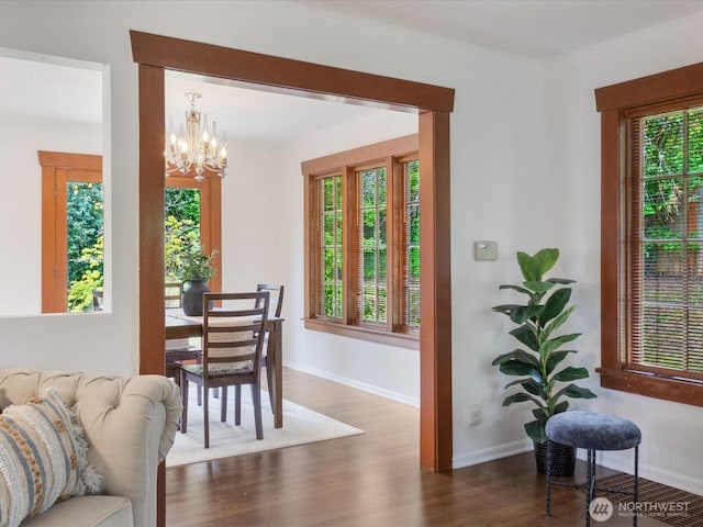 dining space with wood finished floors, a chandelier, and baseboards