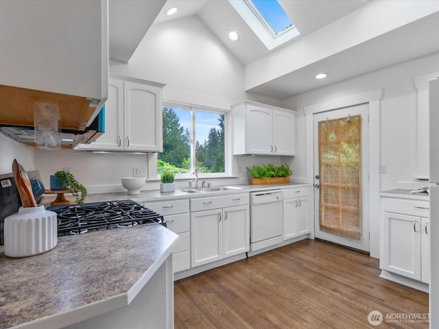 kitchen featuring white dishwasher, a skylight, a sink, range, and white cabinets