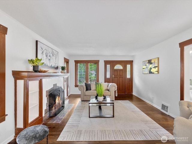 living room with a fireplace with flush hearth, wood finished floors, and baseboards