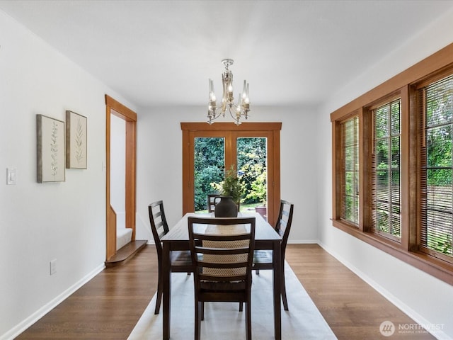 dining space featuring a chandelier, plenty of natural light, and wood finished floors