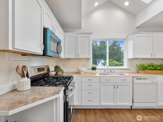kitchen with dishwasher, stainless steel range with gas cooktop, a sink, white cabinetry, and recessed lighting