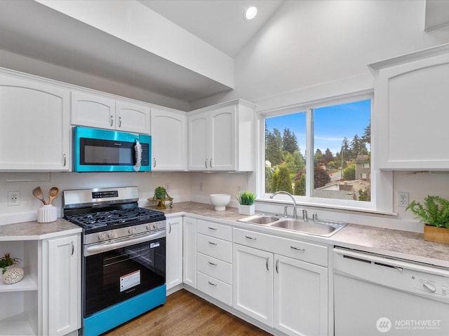 kitchen with stainless steel gas range, dishwasher, a sink, light countertops, and white cabinets