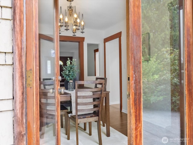 dining space with a chandelier and wood finished floors