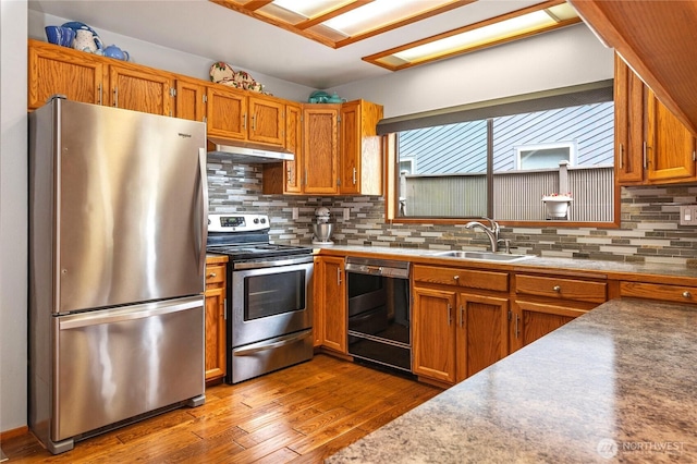 130 E Way To Tipperary St, Shelton, WA 98584 - kitchen featuring stainless steel appliances, a sink, under cabinet range hood, brown cabinetry, and dark wood-style floors