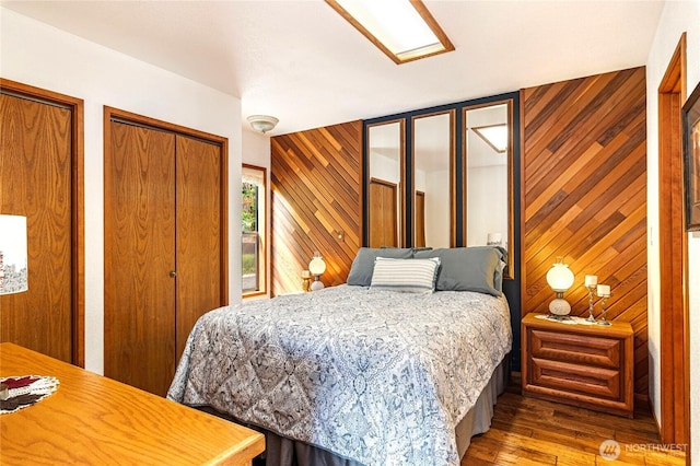 130 E Way To Tipperary St, Shelton, WA 98584 - bedroom featuring wooden walls, hardwood / wood-style flooring, and two closets