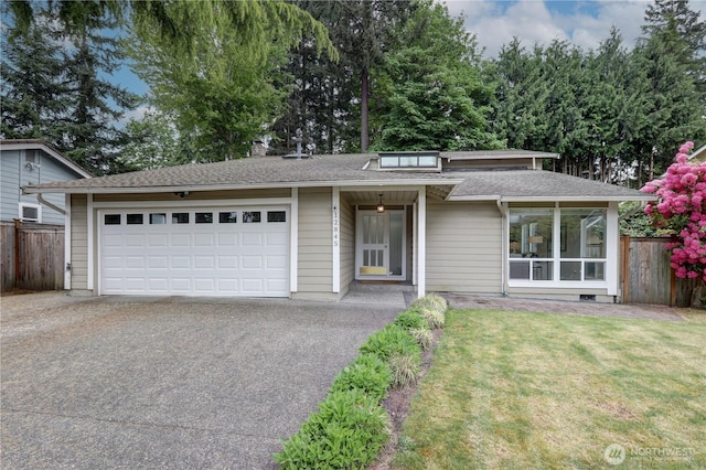 view of front facade with asphalt driveway, a garage, and roof with shingles