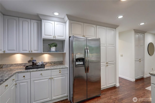 kitchen featuring stainless steel fridge, dark wood-style floors, light stone counters, baseboards, and recessed lighting