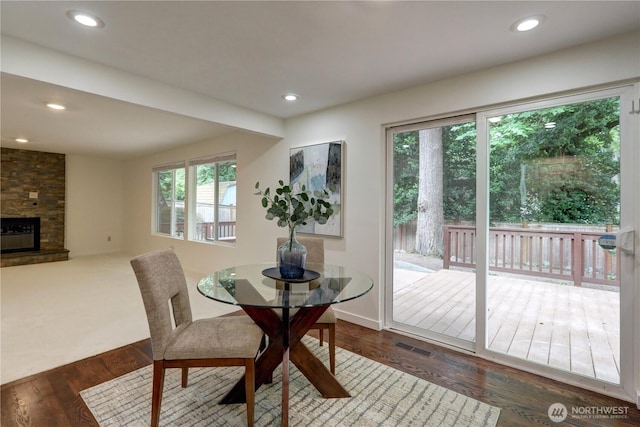 dining space featuring healthy amount of natural light, wood finished floors, a fireplace, and recessed lighting