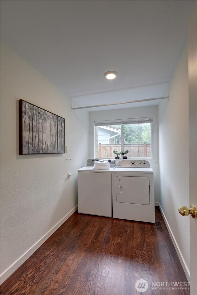 clothes washing area featuring washer and dryer, dark wood-style flooring, and baseboards